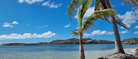 Na praia, espreguiçadeiras, toalhas de praia 