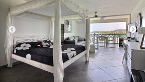 A four-poster bed with a canopy, a balcony with a view, and a seating area with a table and chairs. - ✨A piece of Heaven✨Ocean view, Orient Bay beach & Saint Barthelemy (Saint Martin)