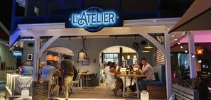 L'Atelier -niminen ravintola, jossa on ulkoterasseja, ja sen kyltissä kerrotaan, että se sijaitsee Orient Bayn alueella.