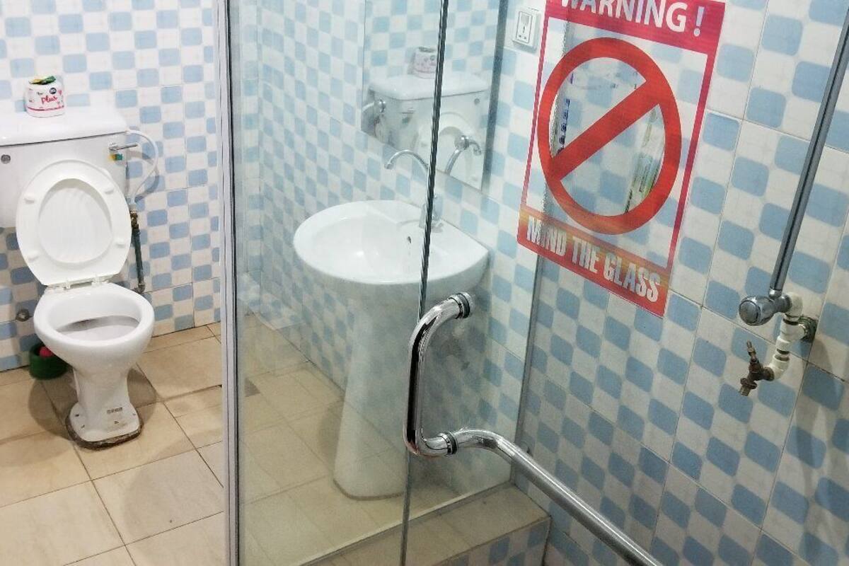 A bathroom with a toilet, sink, and a glass shower enclosure.