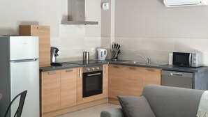 A modern kitchen with a built-in oven, microwave, and coffee maker. - Bright cottage with terrace, garden and parking (Lédenon)