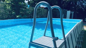 A swimming pool with a metal ladder and a white safety fence. - Villa Francesca Sicily 8, Apartment in Villa on the sea (casteldaccia)