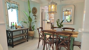 Un comedor con una mesa y sillas de madera, un farol colgante y una planta en maceta.