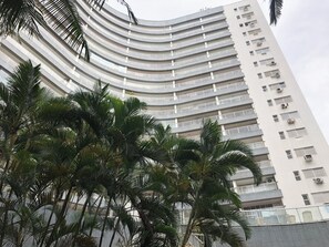 Un immeuble de grande hauteur doté de nombreux balcons et de plusieurs unités de climatisation.