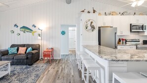 A modern kitchen with white cabinets, a marble countertop, and a built-in oven. - 4BR 2BA OCEANFRONT COTTAGE- Fish, Fun & Sun! Relax, Recharge, Repeat!- Book Now! (Oak Island)