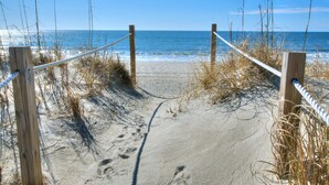 A sandy beach path leading to the ocean, surrounded by wooden posts and rope barriers. - 4BR 2BA OCEANFRONT COTTAGE- Fish, Fun & Sun! Relax, Recharge, Repeat!- Book Now! (Oak Island)