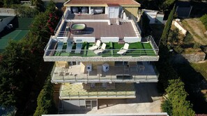A two-story residential building with a rooftop terrace featuring a swimming pool, lounge chairs, and a covered patio area. - Villa Francesca Sicily 23, Apartment in Villa on the sea (Casteldaccia)