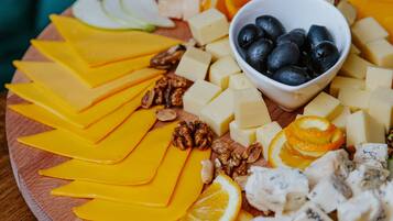 Une planche en bois sur laquelle sont disposés divers fromages, fruits et fruits secs.