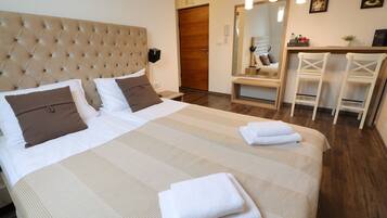 A neatly made bed with a striped bedspread, two pillows, and folded towels.