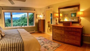 A bedroom with a large window, a bed, a dresser, and a mirror. - Mountain-view House ~ Mins To Middlebury, Flex Cancellation Policy (Cornwall)