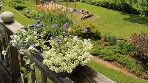 A garden with a wooden deck, a pergola, and a variety of plants and flowers. - Mountain-view House ~ Mins To Middlebury, Flex Cancellation Policy (Cornwall)