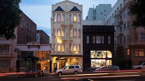A multi-story building with a corner entrance, large windows, and a visible fire escape.