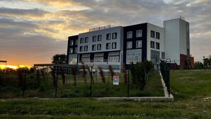 Un bâtiment moderne à plusieurs étages, doté de grandes fenêtres et d’un toit plat.