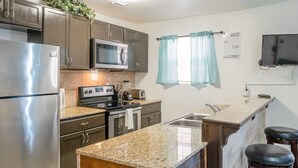 A compact kitchen with a refrigerator, microwave, stove, and sink. - Sun Ray #2B - Pet Friendly, 3min Walk to Beach (South Padre Island)