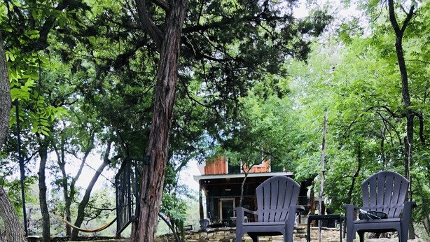 Eine Steintreppe führt zu einer Holzdiele mit Adirondack-Stühlen.