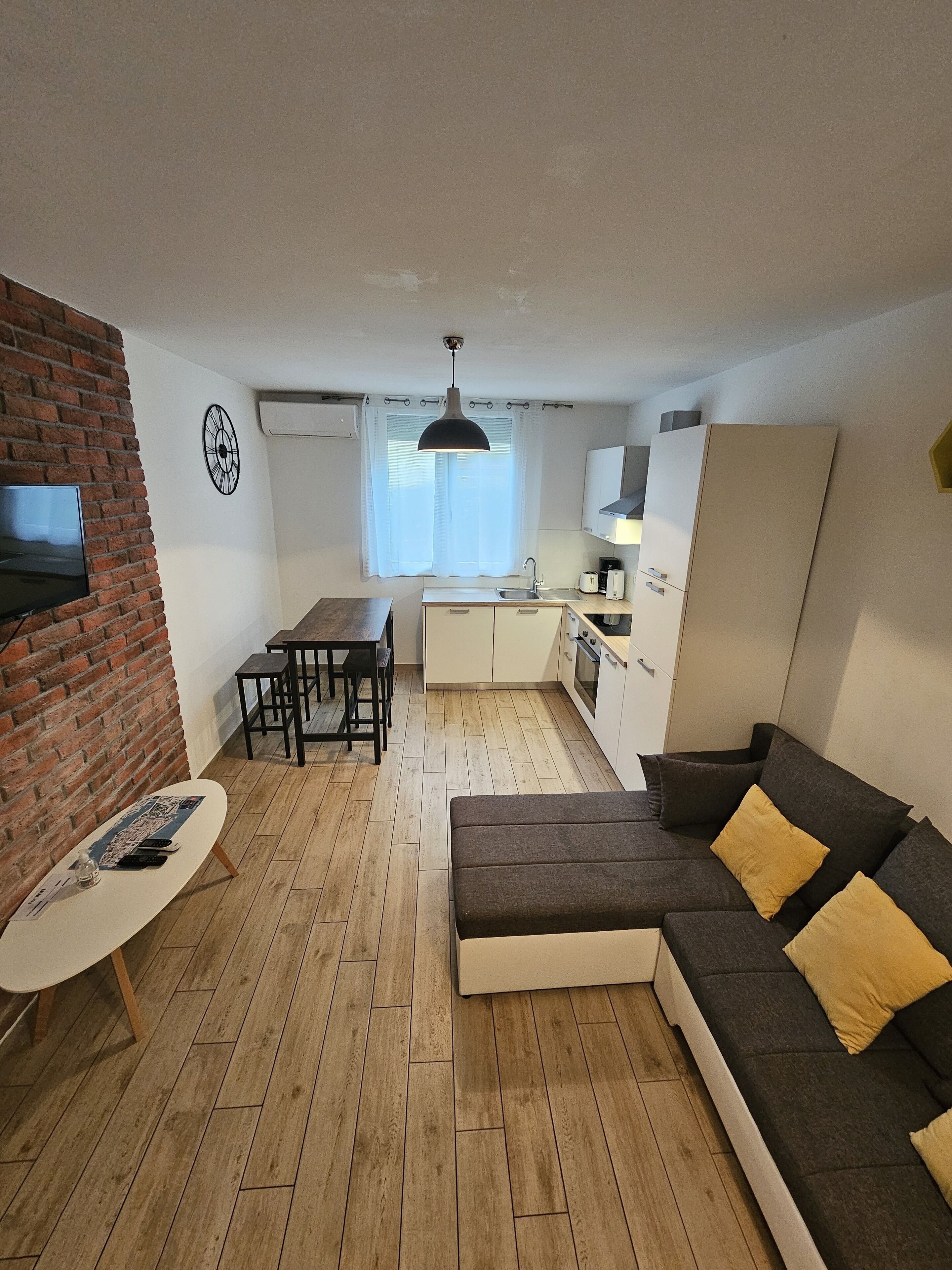 A compact living space with a dining area, kitchenette, and seating area.
