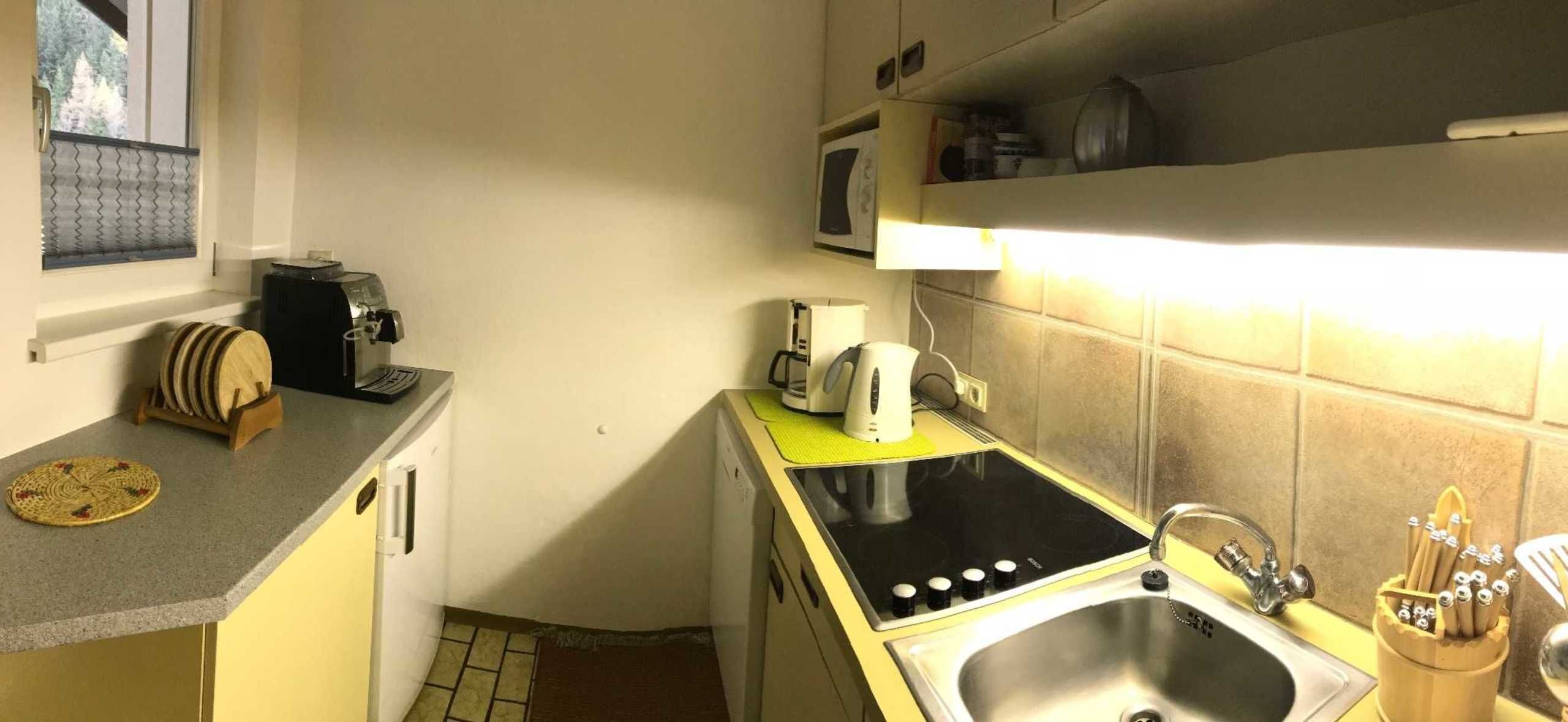 A compact kitchen with a stove, sink, and a microwave.
