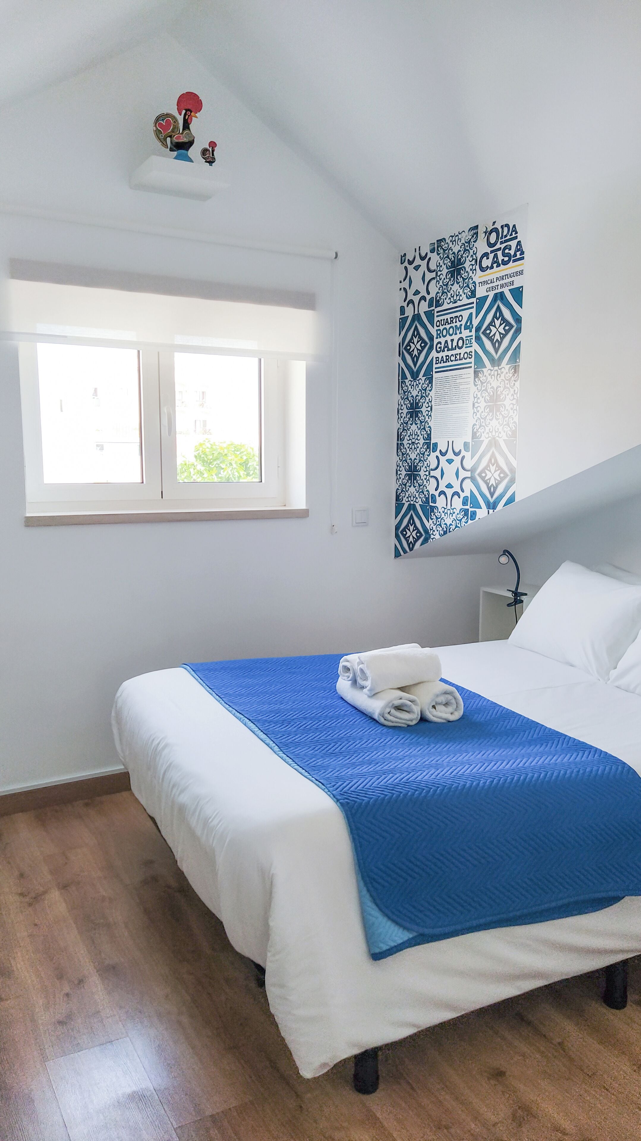 Ein Schlafzimmer mit einem Bett, einem Fenster und einer Wanddekoration.