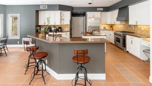 Cozinha moderna com ilha central, banquetas e uma janela ampla.