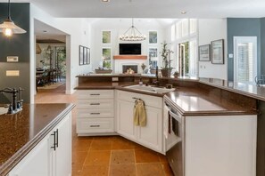 A kitchen with a central island, white cabinetry, and a built-in oven.