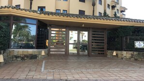Un edificio con ingresso piastrellato, cancello e cartello che indica 'Calle Trajano N5'.