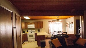 Un espacio habitable compacto con kitchenette, comedor y zona de estar.