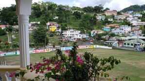Vista de una zona residencial con casas en una colina, un campo deportivo y una estructura de columnas blancas al frente.