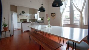 A modern kitchen with a central island, pendant lighting, and a view to the outside.