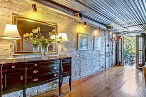 Cozy retreat with a rustic stone wall, polished floor, and sloped ceiling with exposed beams.