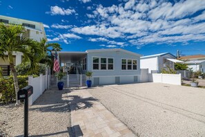 A single-story building with a covered porch, a flag, and a mailbox. - Geat Fishing & Ocean breeze, 40 ft dock for your boat with direct ocean access. (Tavernier)