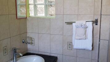 A bathroom with a sink, mirror, and towel rack.