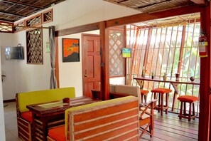 Traditional room with a thatched ceiling, wooden table, and comfortable seating area.