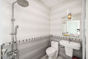 A bathroom with a shower, toilet, and sink.