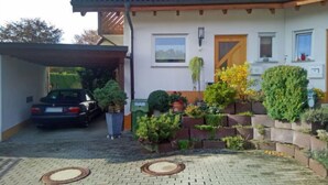 A house with a tiled roof, a garage, and a landscaped garden with various plants and shrubs.