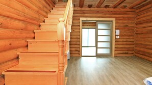 Un escalier en bois mène à une porte dont les panneaux sont en verre dépoli.