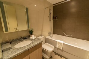 Un baño moderno con lavamanos doble, inodoro, bañera y ducha.