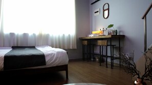 A bedroom with a bed, a desk with a lamp, a mirror, and a potted plant. - Dongdaemun PR. Mondern Studio (Seoul)
