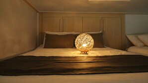 A bedroom with a bed, a headboard, and a decorative spherical light fixture. - Dongdaemun PR. Mondern Studio (Seoul)