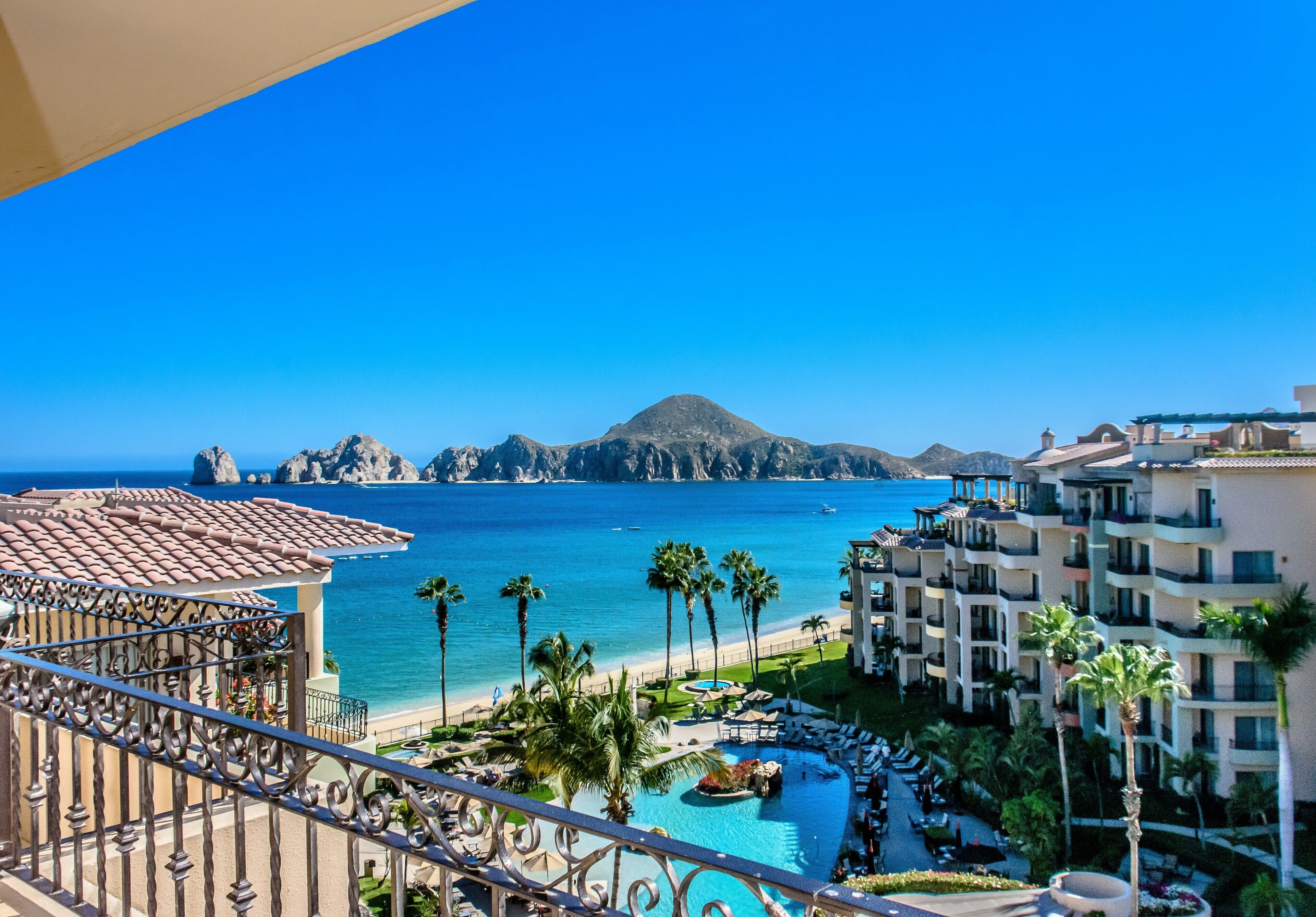 Un resort con piscina, playa y vista al océano.