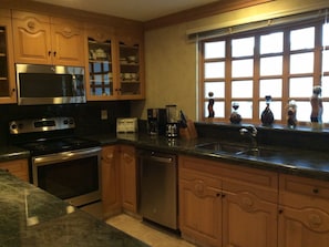 Kitchen with new granite and stainless appliances.