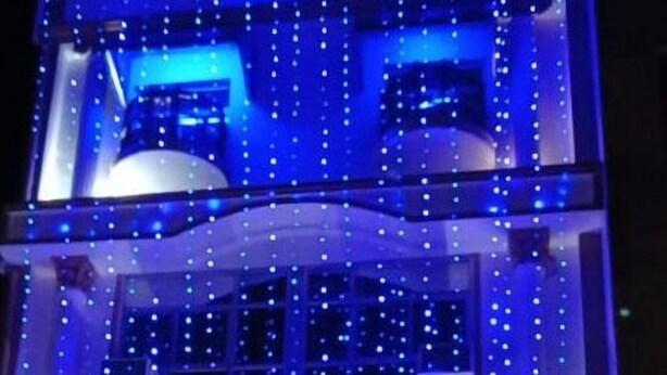 A building with multiple floors, each illuminated with blue lights. The building has a sign that reads "TARA TOWER". - Hotel Tara Tower (Koderma)