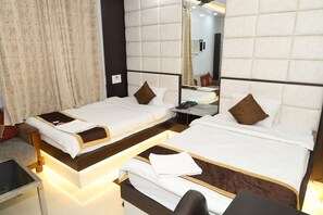 A hotel room with two single beds, a desk, and a mirror. - Hotel Tara Tower (Koderma)