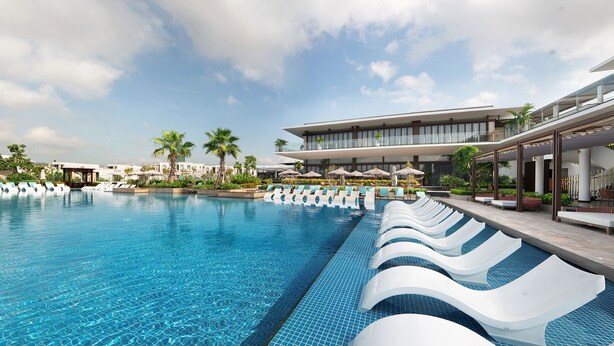 A modern hotel pool with tiered seating, palm trees, and a clear blue sky. - Oakwood Ha Long (Bai Chay)