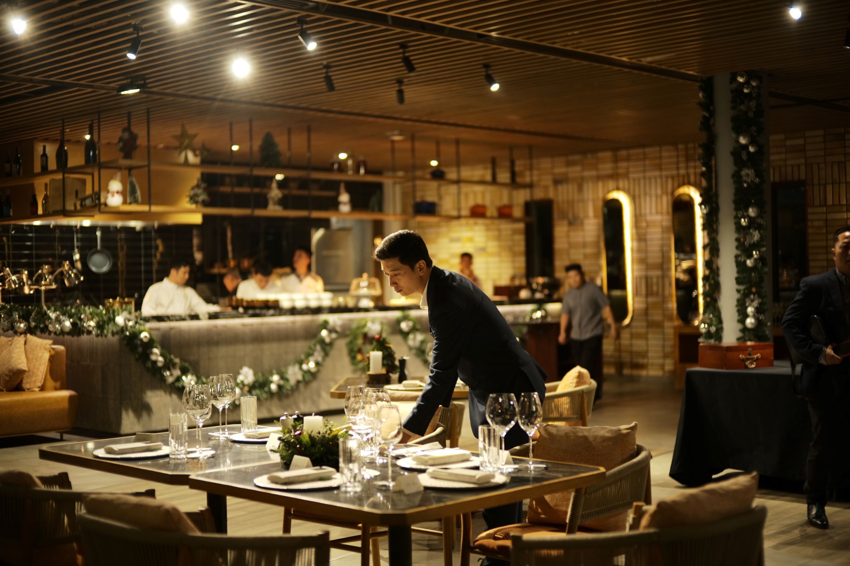 A restaurant with a long dining table set for a meal, surrounded by chairs.