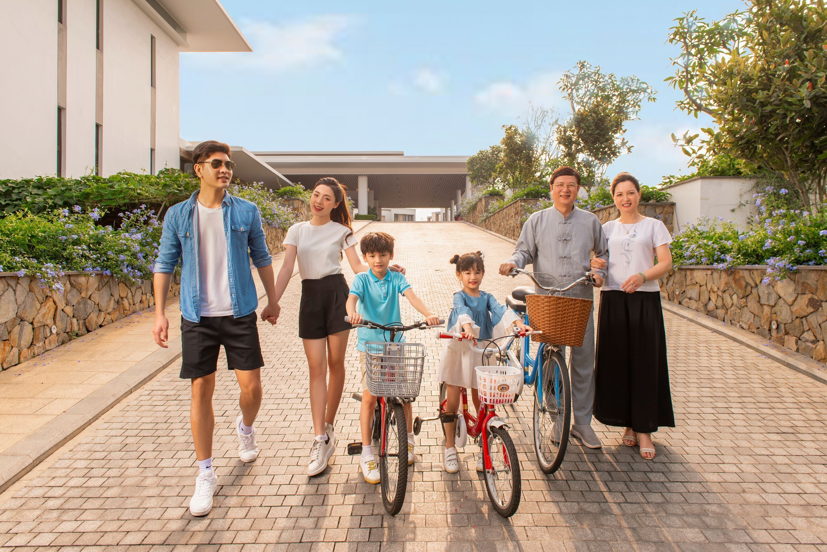A family walking on a paved pathway with a modern building in the background.
