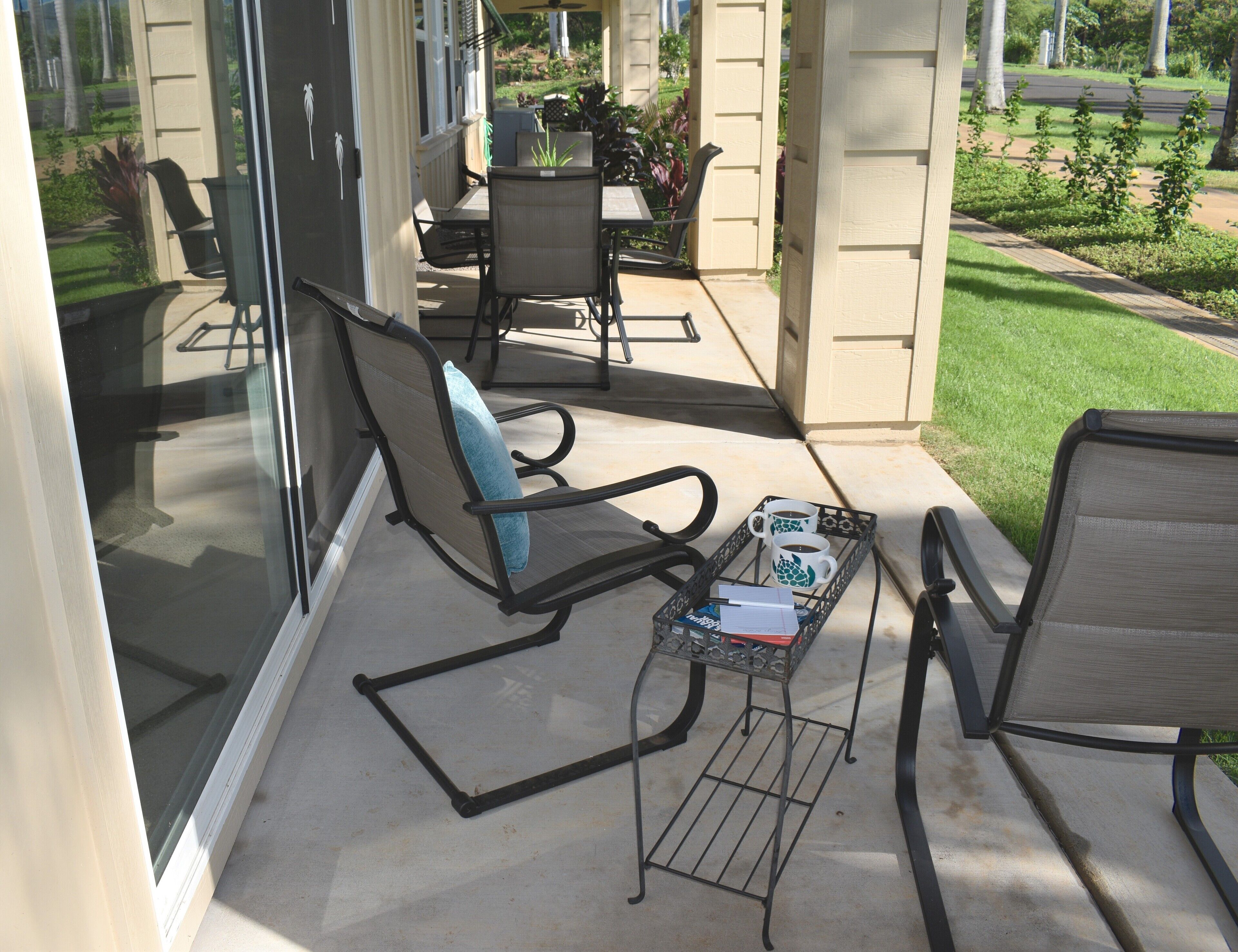 Un patio couvert aménagé avec du mobilier d’extérieur, notamment des chaises et une table.