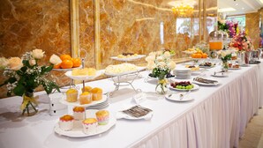 Una mesa de buffet con diversos alimentos y un cartel que indica 'Desayuno tipo buffet'.