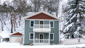 A two-story house with a balcony, a garage, and a snow-covered landscape. - Blocks to Downtown. Charming 3 Bed, Entire House (Stillwater)