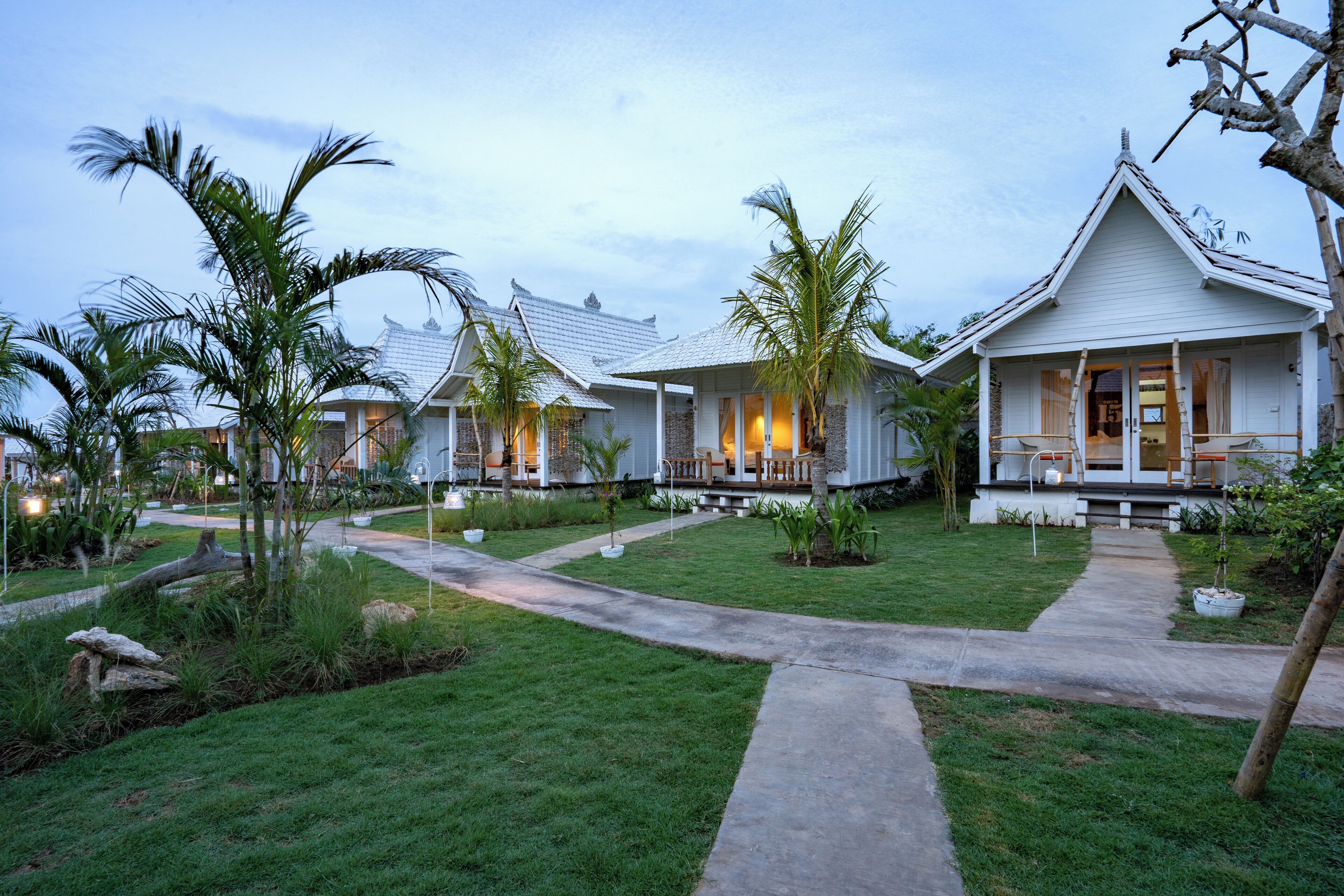 A resort with multiple bungalow-style buildings, each with a porch and a small garden area.