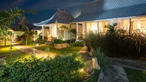 Un edificio de estilo tradicional con tejados de tejas y un jardín bien cuidado.